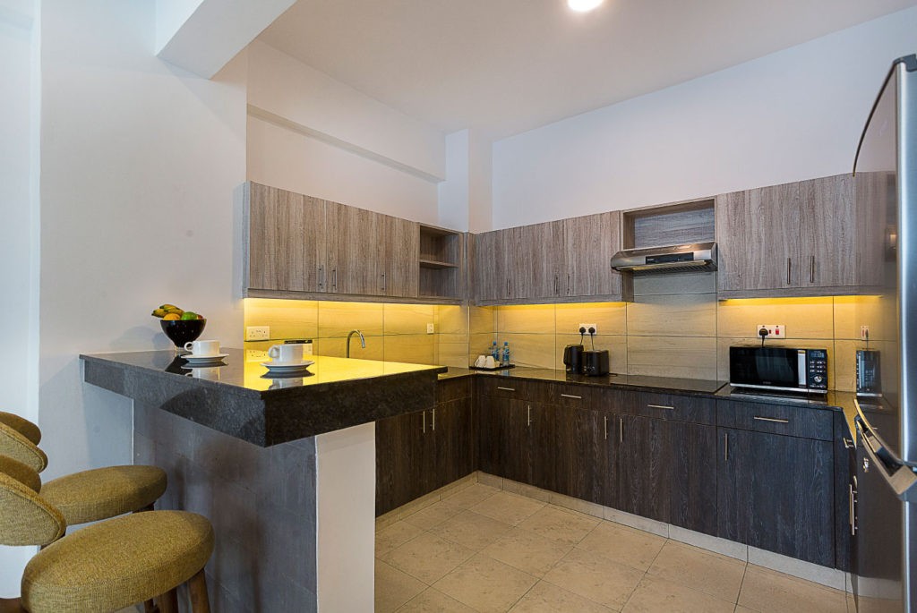 A full kitchen in a L'Aziz Suites apartment, with worktop, cupboards and space to prepare a simple meal.